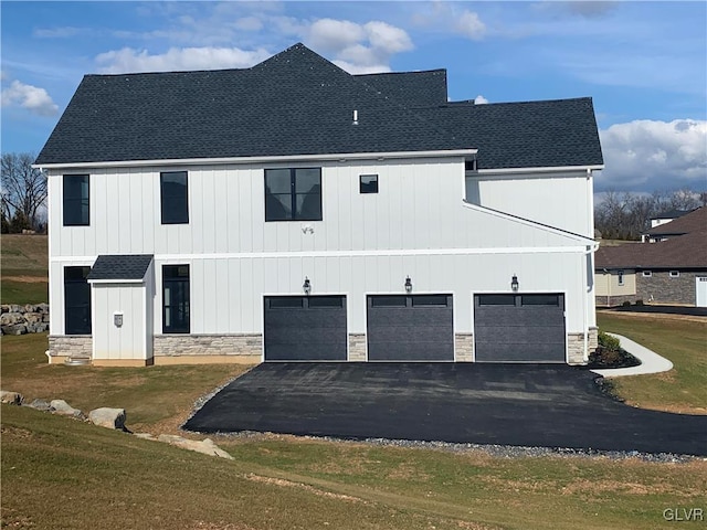 view of side of property featuring a garage and a yard