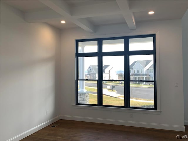 empty room featuring dark hardwood / wood-style flooring, beam ceiling, coffered ceiling, and plenty of natural light