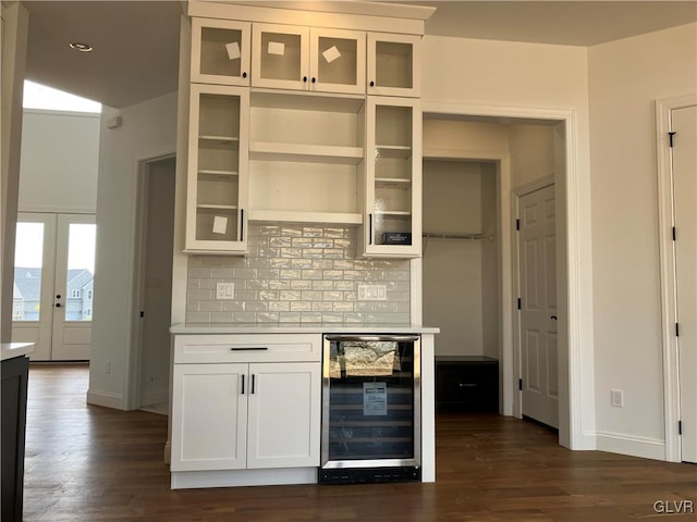 bar featuring wine cooler, white cabinetry, dark wood-type flooring, and decorative backsplash