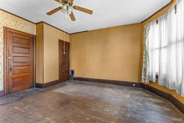 empty room with dark hardwood / wood-style floors, ceiling fan, and ornamental molding