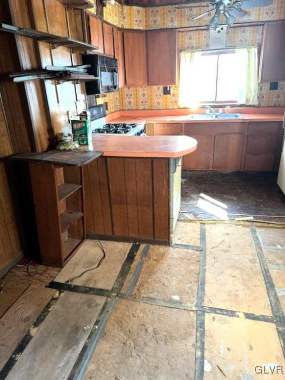 kitchen with white stove, ceiling fan, and sink