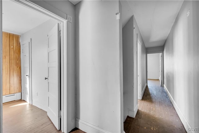 corridor featuring baseboard heating and light hardwood / wood-style flooring