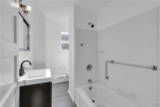 full bathroom featuring vanity, baseboard heating, wood-type flooring, washtub / shower combination, and toilet