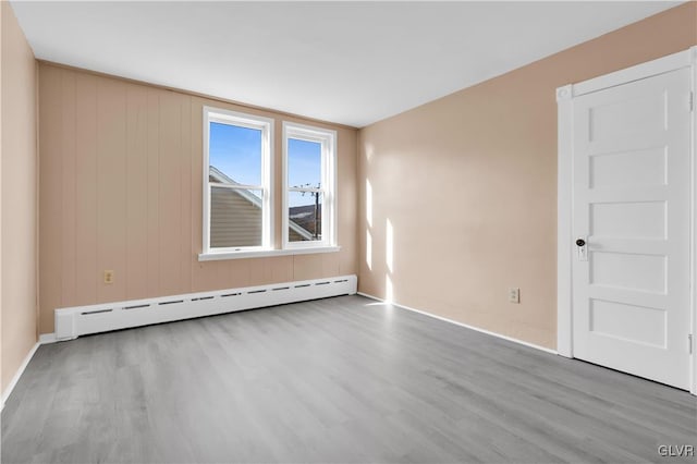 spare room with light hardwood / wood-style floors and a baseboard heating unit