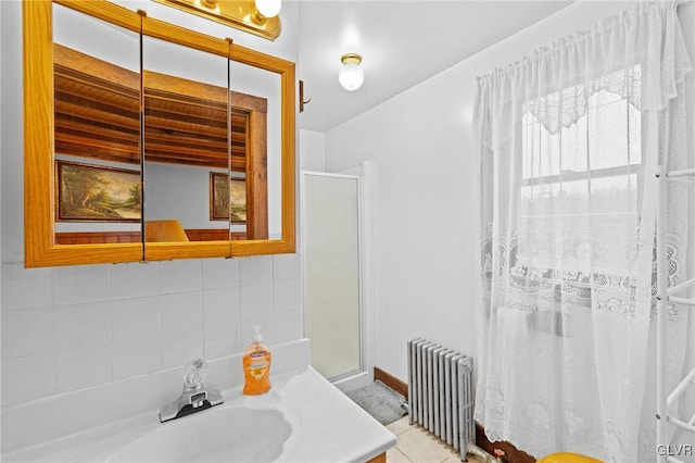 bathroom with walk in shower, tile patterned flooring, tasteful backsplash, radiator, and vanity