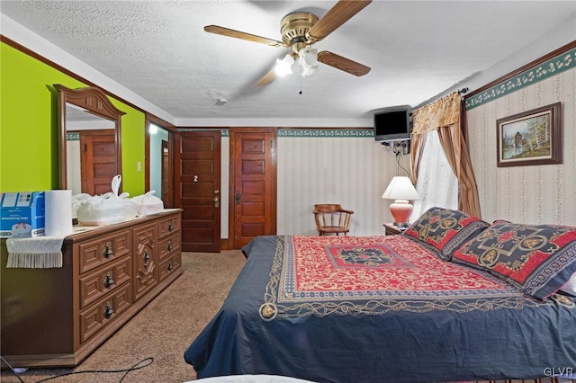 carpeted bedroom featuring a textured ceiling and ceiling fan