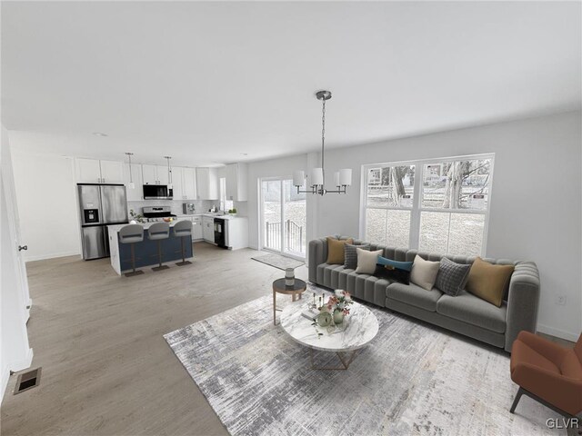 living room with a notable chandelier and light wood-type flooring