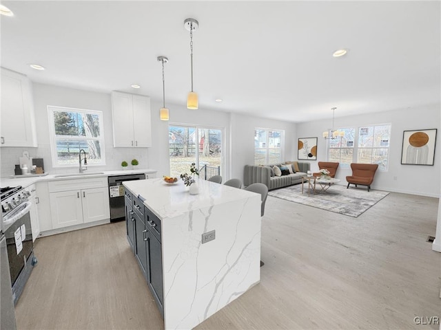 kitchen featuring sink, stainless steel appliances, white cabinetry, and decorative backsplash