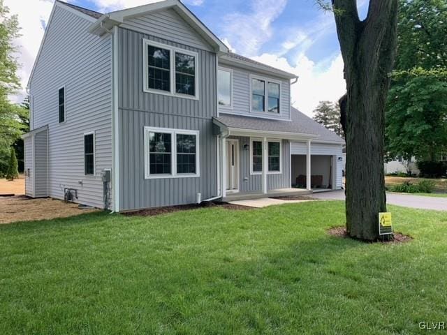 rear view of house featuring a lawn