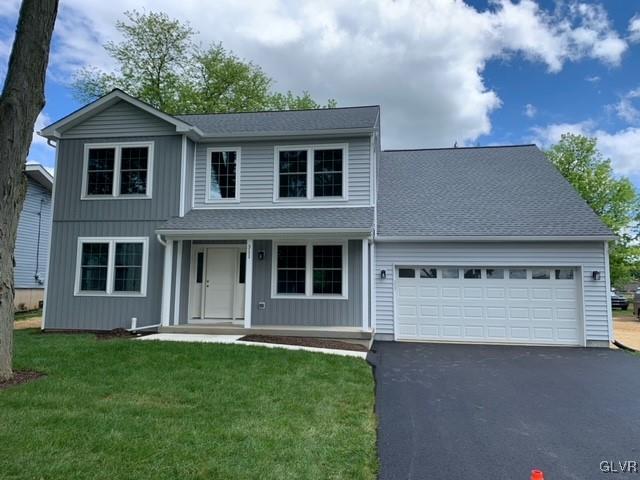 front facade featuring a garage and a front lawn