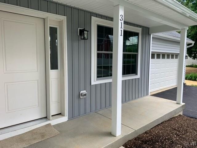 property entrance featuring a porch and a garage