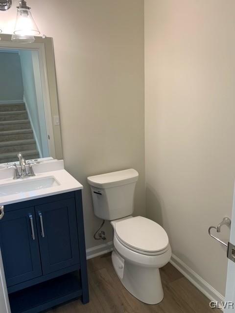 bathroom with vanity, wood-type flooring, and toilet