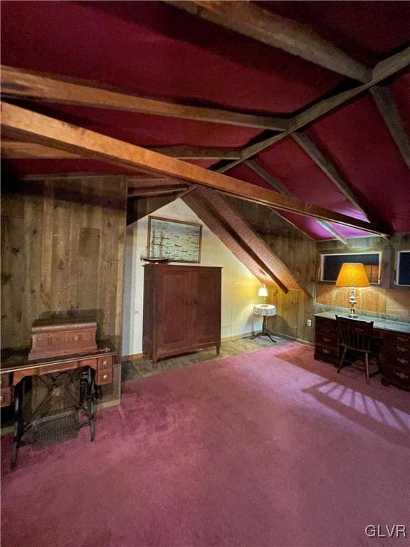 interior space featuring carpet flooring, vaulted ceiling with beams, and wooden walls