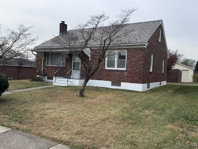 view of front facade featuring a front yard and an outdoor structure