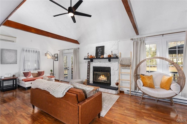 living room featuring lofted ceiling with beams, wood-type flooring, an AC wall unit, and a fireplace