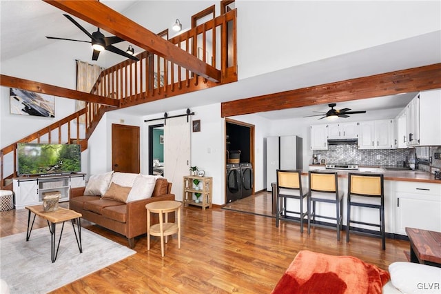 living room featuring a barn door, light hardwood / wood-style flooring, and sink