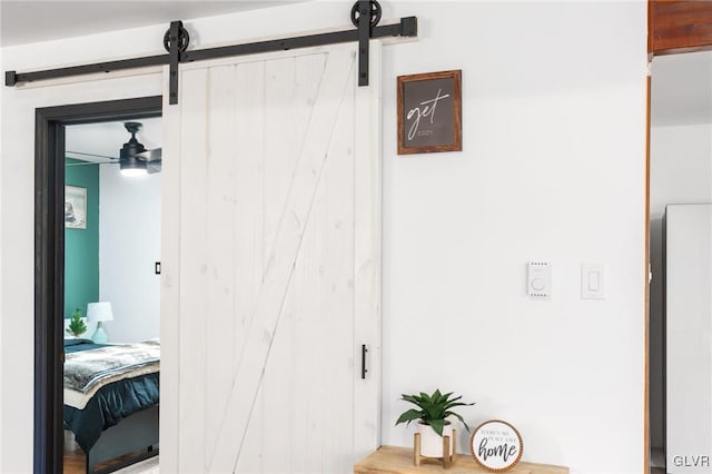 interior space featuring ceiling fan and a barn door