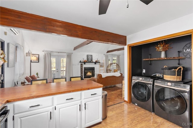 laundry room featuring ceiling fan, a healthy amount of sunlight, light wood-type flooring, and independent washer and dryer