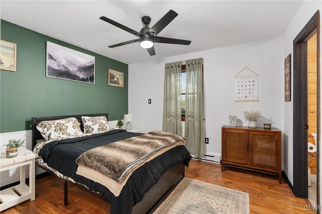 bedroom featuring hardwood / wood-style floors, ceiling fan, and baseboard heating