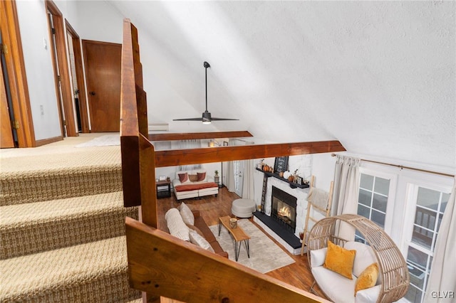 living room featuring a textured ceiling, ceiling fan, hardwood / wood-style floors, and vaulted ceiling