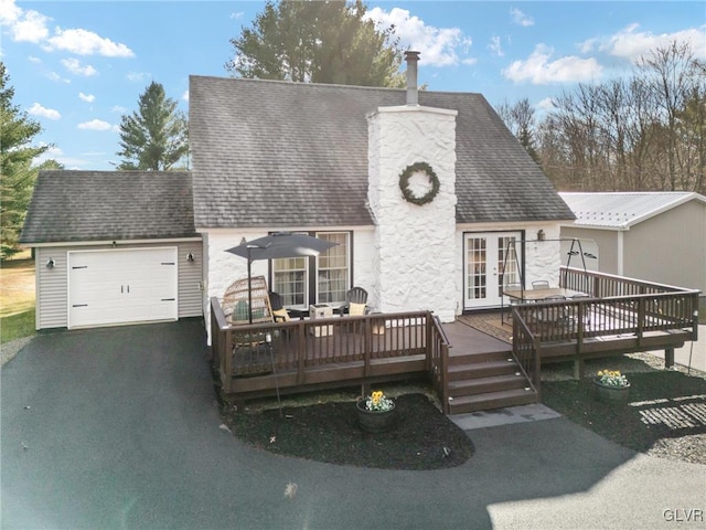 view of front of house featuring a wooden deck, french doors, and a garage