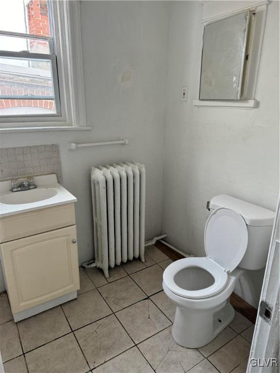 bathroom featuring tile patterned floors, radiator, vanity, and toilet