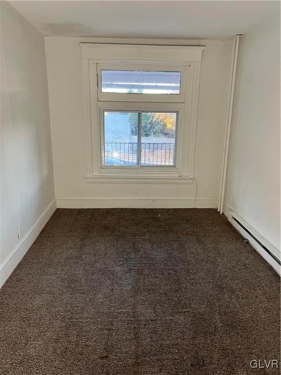 spare room with dark colored carpet