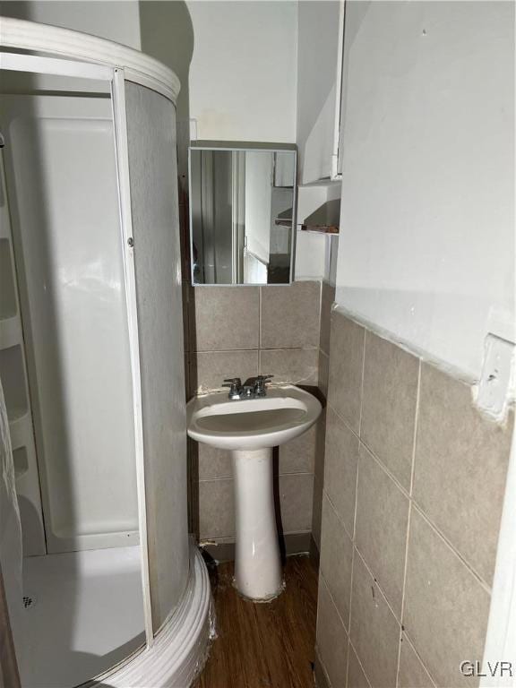 bathroom featuring hardwood / wood-style flooring, tile walls, and sink