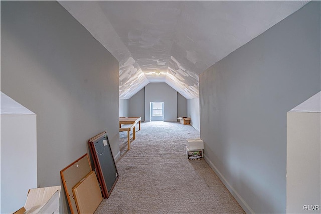 additional living space featuring light carpet and vaulted ceiling