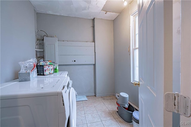 clothes washing area with independent washer and dryer and light tile patterned floors