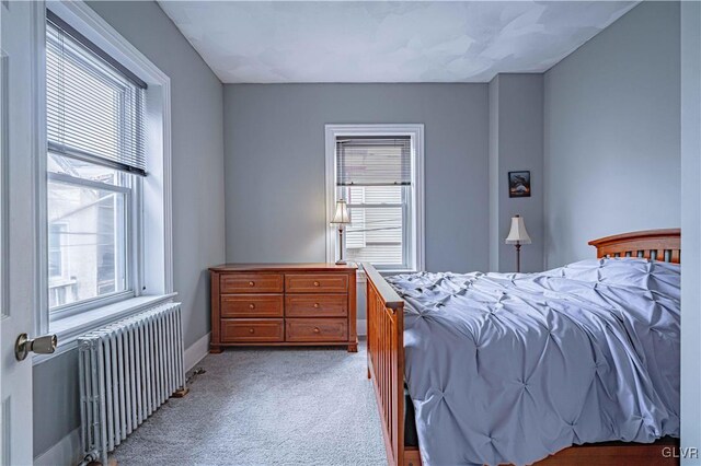 carpeted bedroom featuring radiator