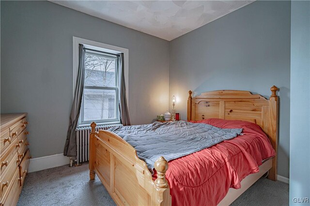 bedroom featuring light carpet and radiator heating unit