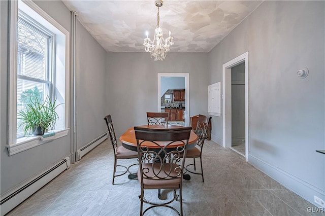 dining space with a chandelier and a baseboard heating unit