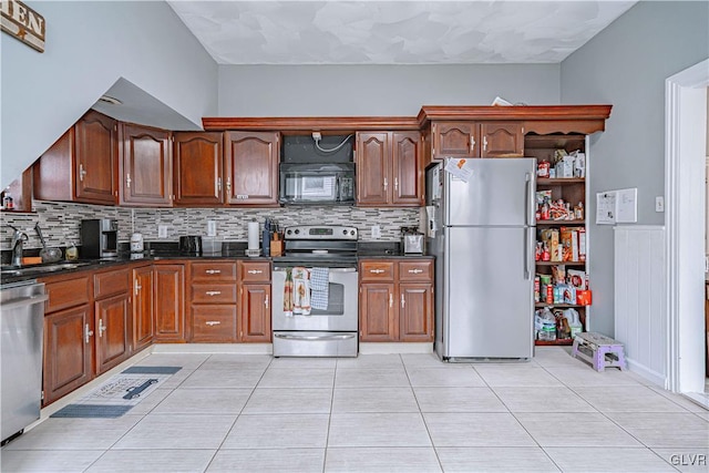 kitchen with decorative backsplash, sink, light tile patterned floors, and stainless steel appliances