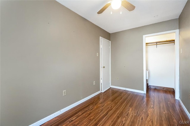 unfurnished bedroom with dark hardwood / wood-style flooring, a closet, and ceiling fan