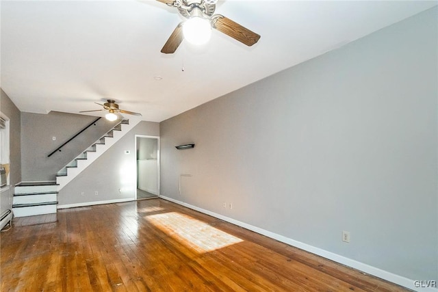 unfurnished living room featuring ceiling fan and dark hardwood / wood-style flooring