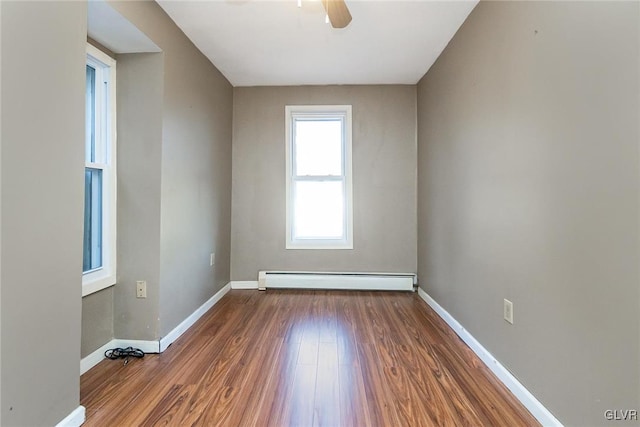 unfurnished room with dark hardwood / wood-style flooring, ceiling fan, and a baseboard heating unit