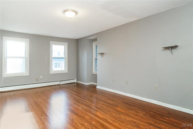 spare room featuring hardwood / wood-style flooring and baseboard heating