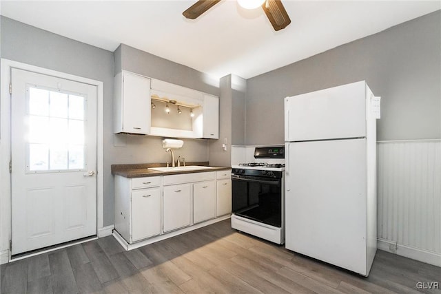 kitchen featuring white appliances, ceiling fan, sink, wood-type flooring, and white cabinets