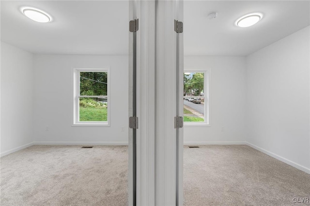 carpeted spare room featuring a wealth of natural light