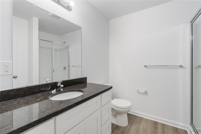 bathroom featuring toilet, an enclosed shower, wood-type flooring, and vanity