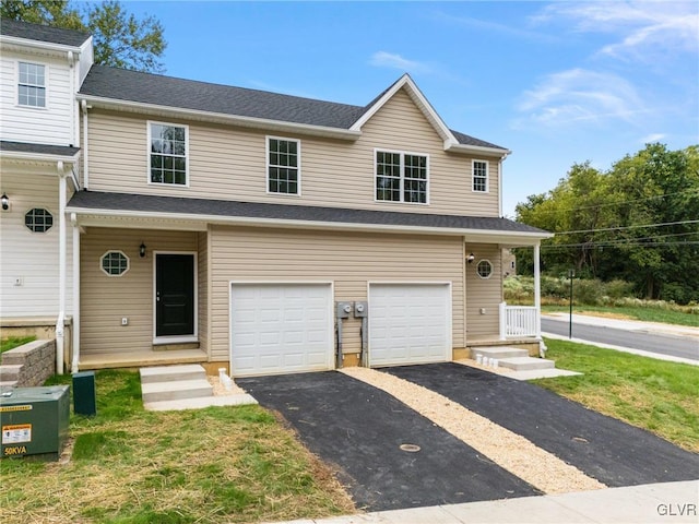 multi unit property featuring an attached garage and aphalt driveway