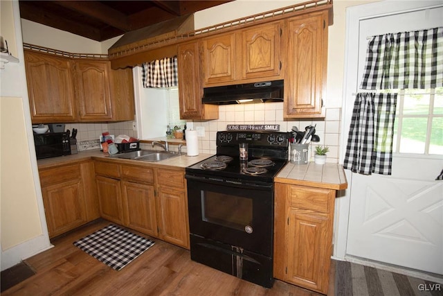 kitchen with tasteful backsplash, sink, electric range, beamed ceiling, and dark hardwood / wood-style floors