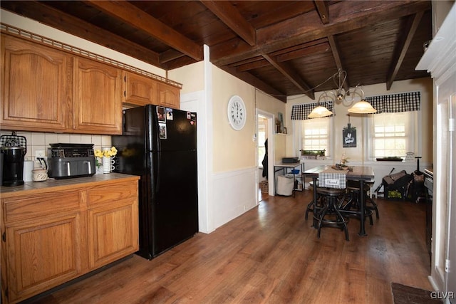 kitchen featuring dark wood-type flooring, black fridge, beamed ceiling, decorative backsplash, and wood ceiling