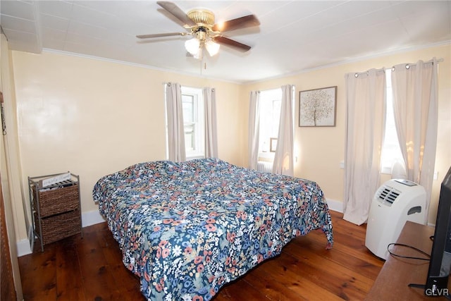 bedroom with ornamental molding, ceiling fan, and dark wood-type flooring