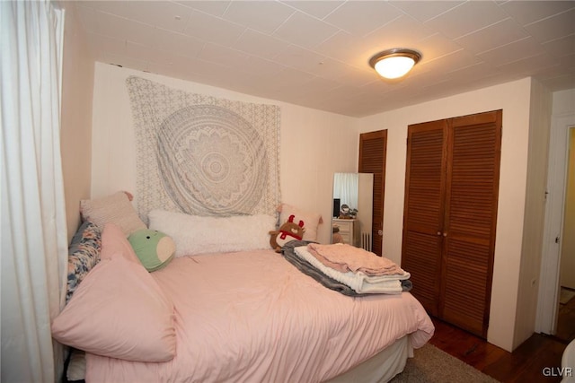 bedroom with dark wood-type flooring