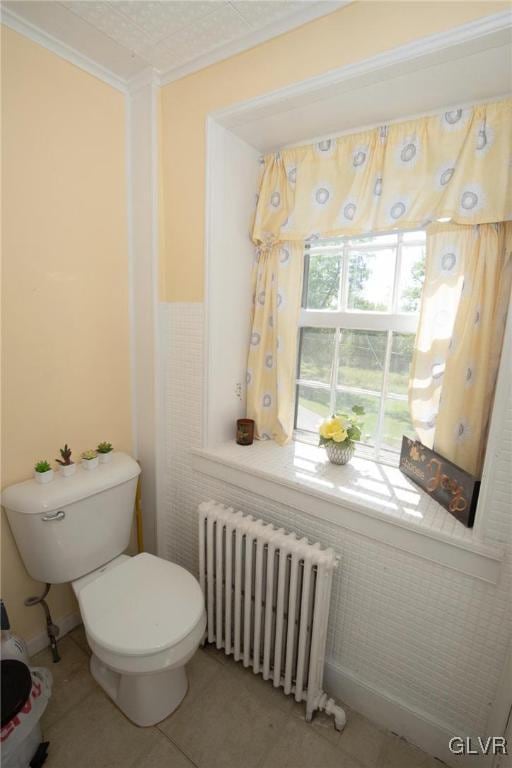 bathroom with tile patterned floors, radiator heating unit, ornamental molding, and toilet