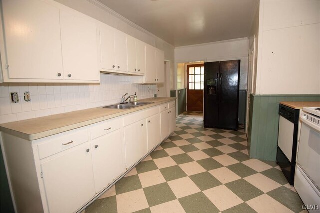 kitchen featuring black fridge, sink, ornamental molding, white range oven, and white cabinetry