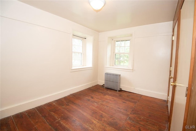 unfurnished room featuring radiator and dark hardwood / wood-style flooring