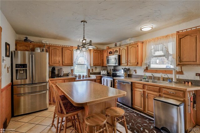 3479 Mango Dr, Lehigh Township, PA 18038 - kitchen featuring stainless steel appliances, a sink, a center island, and brown cabinets